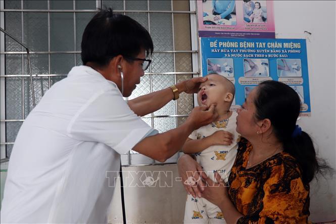 Bác sĩ Nguyễn Văn Xiếu, Trưởng Trạm y tế xã Trần Phán, huyện Đầm Dơi (Cà Mau) tiếp nhận khám bệnh cho trẻ dưới 6 tuổi.